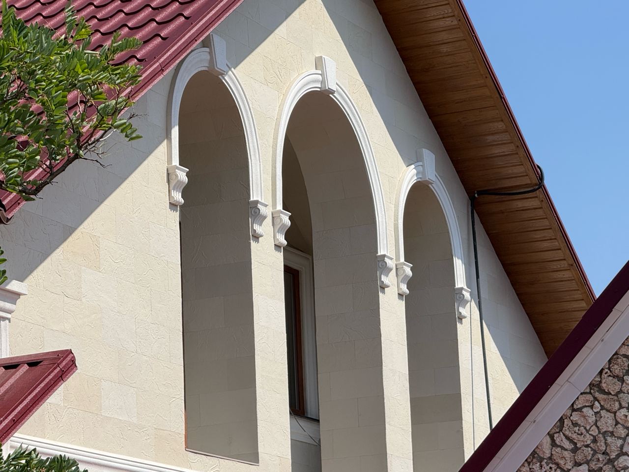 Arcadă de fereastră placată cu piatră flexibilă, cheie de boltă și console albe