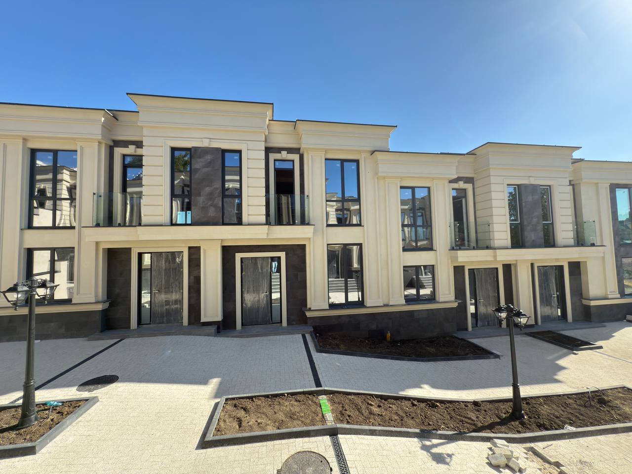 Fațada principală a complexului: două registre de piatră flexibilă, pilaștri și balustrade de sticlă