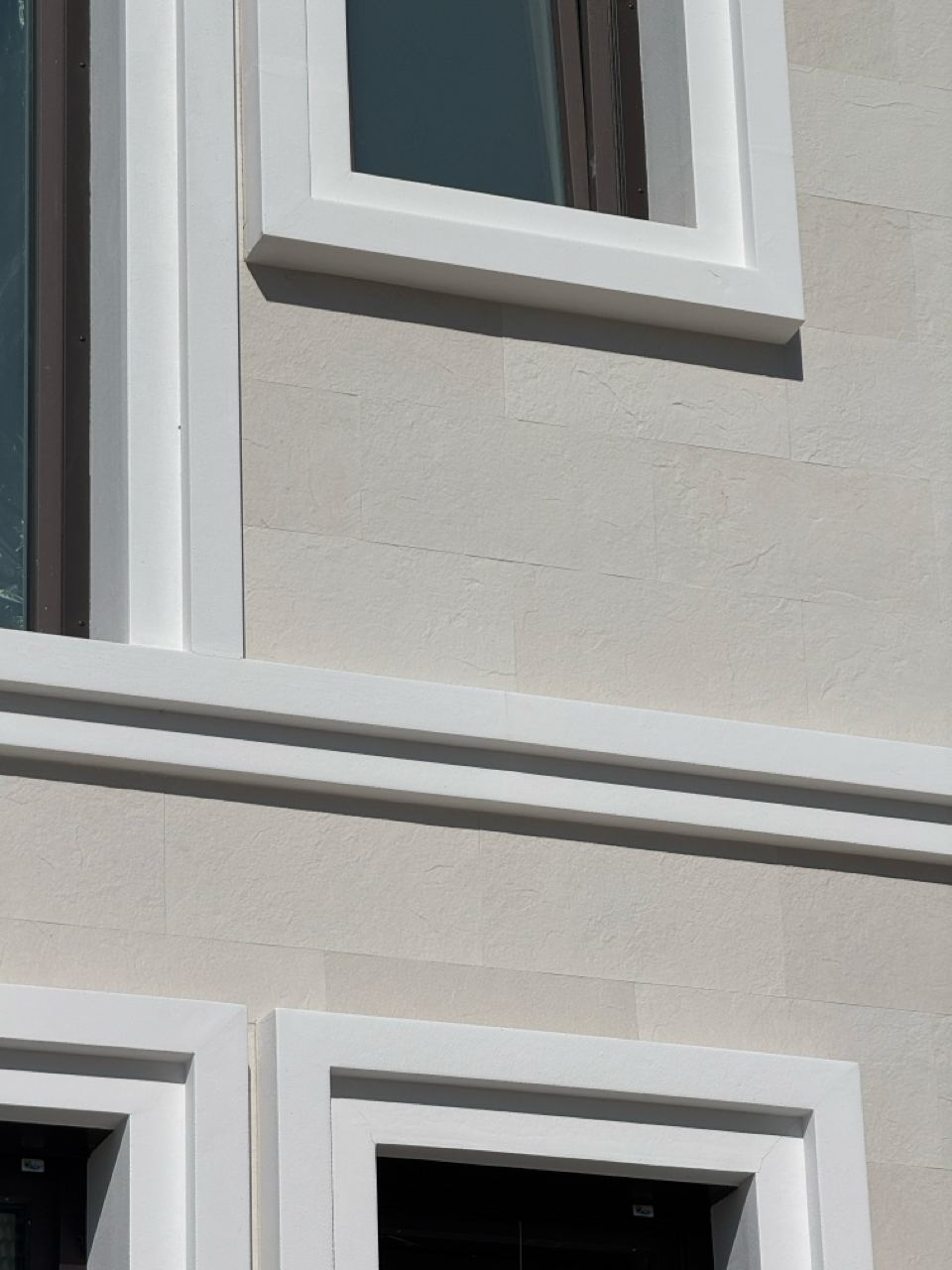 Câmp de piatră flexibilă în jurul unei ferestre cu ancadrament alb, de aproape